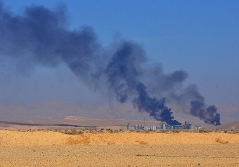 A general view shows smoke billowing from an oil field on the eastern outskirts of Homs