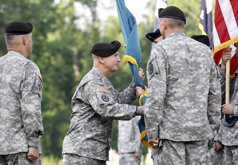 Maj. Gen. H.R. McMaster, center left, hands the Maneuver Center of Excellence flag to Command Sgt. Maj. James Carabello as he assumes command of the MCoE at Fort Benning, Ga.