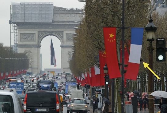 A French flag hangs next to the red flag of communist China in Paris. (AP)