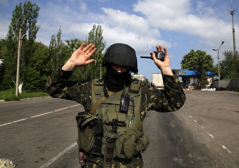 An Ukrainian army officer gives directions to a photographer to move away at a road-block north of the eastern Ukrainian town of Slaviansk