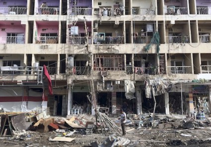 Iraqi civilians inspect the aftermath of a car bombing in the southeastern district of New Baghdad, Iraq, June 8