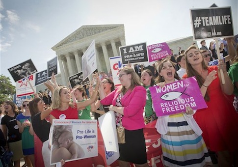 Demonstrator react to hearing the Supreme Court's decision on the Hobby Lobby case outside the Supreme Court