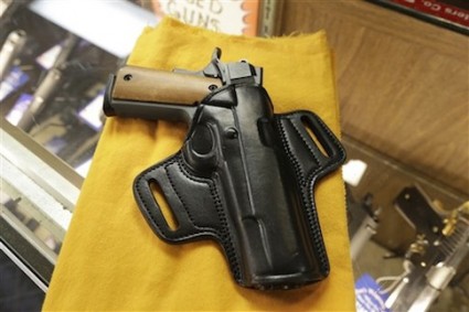 A semi-automatic handgun and a holster are displayed at a North Little Rock, Ark., gun shop