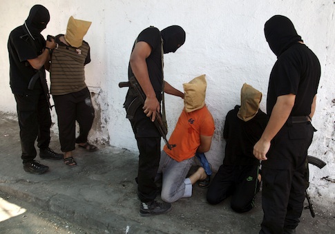Hamas militants grab Palestinians suspected of collaborating with Israel, before executing them in Gaza City August 22