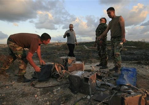 Lebanese army soldiers inspect what they say are destroyed parts of an Israeli spying device planted in Adloun village, south Lebanon, on Friday Sept. 5, 2014. Israel remotely detonated a spying device planted in south Lebanon
