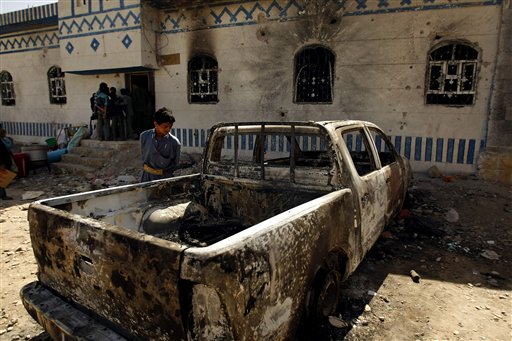 A Yemeni youth looks at a vehicle destroyed during a police raid on a hideout of al-Qaida militants in Arhab region, north of Sanaa, Yemen