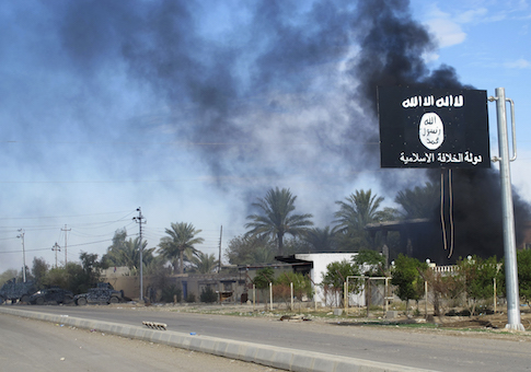 Smoke raises behind an Islamic State flag after Iraqi security forces and Shiite fighters took control of Saadiya in Diyala province from Islamist State militants