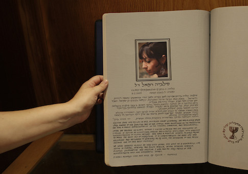 An Israeli worker displays a photo of former Mossad agent Sylvia Rafael in a memorial book in the Intelligence Heritage and Commemoration Center at Gliliot Junction near Tel Aviv