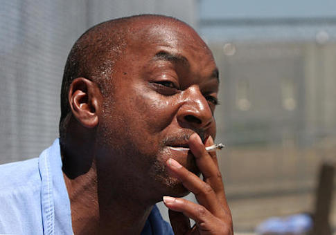 An inmate at a California state prison enjoys a hand-rolled cigarette in the prison's minimum security yard