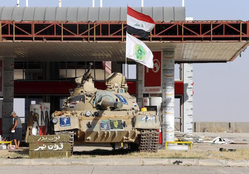 A tank belonging to the Shi'ite Badr Brigade militia takes position in front of a gas station in Suleiman Beg, northern Iraq in this September 9, 2014