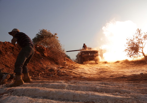 Rebel fighter fires a vehicle's weapon during what the rebels said is an offensive to take control of the al-Mastouma army base near Idlib city