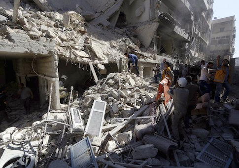 Residents and Civil Defence members look for survivors at a damaged site after what activists said was a barrel bomb dropped by forces loyal to Syria's President Bashar al-Assad and hit a school and a residential building