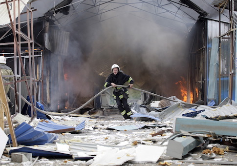 Firefighter works to extinguish a fire at a local market which was recently damaged by shelling in Donetsk