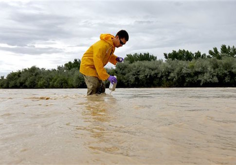Hydrologic Technician Ryan Parker gathers water samples from the San Juan River