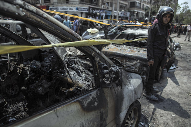 An Egyptian policeman stands guard at the site of a car bombing that killed n Egyptian policeman stands guard at the site of a car bombing that killed Hesham Barakat / AP