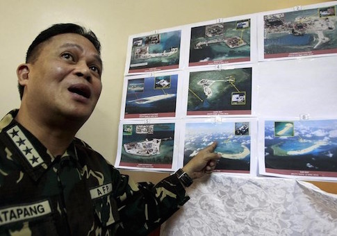 Armed Forces of the Philippines (AFP) Chief of Staff Gregorio Pio Catapang shows some images of the structures being built by China at the disputed islands during a news conference at the AFP headquarters in Manila April 20, 2015