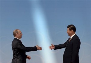 Russian President Vladimir Putin, left, is greeted by Chinese President Xi Jinping