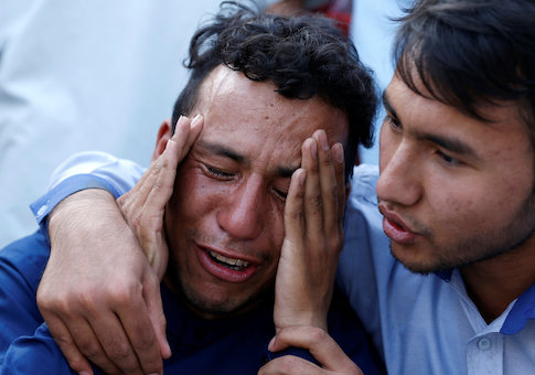 An Afghan man weeps outside a hospital after a suicide attack in Kabul, Afghanistan