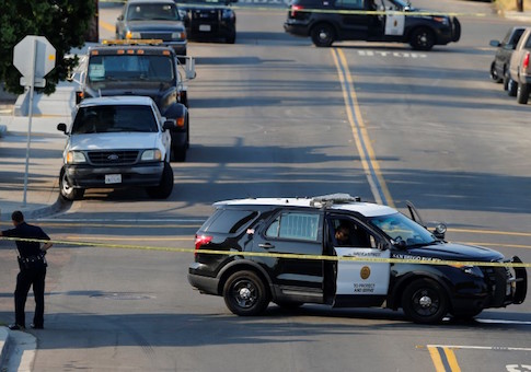 San Diego police officers investigate the scene where an officer was fatally shot and another was injured at a traffic stop late on Thursday, in San Diego