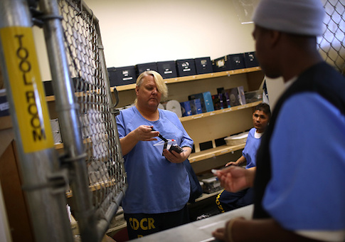A Valley State Prison inmate hands out supplies to a fellow inmate during a cosmetology class