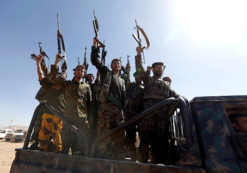 Newly recruited Houthi fighters chant slogans as they ride a military vehicle during a gathering in the capital Sanaa