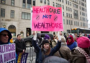 Health care activists lift signage promoting the Affordable Care Act