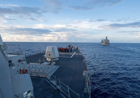 The Arleigh Burke-class guided-missile destroyer USS Dewey prepares for a replenishment-at-sea in the South China Sea