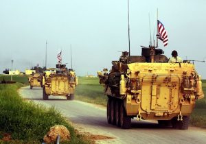 US forces, accompanied by Kurdish People's Protection Units (YPG) fighters, drive their armoured vehicles near the northern Syrian village of Darbasiyah, on the border with Turkey