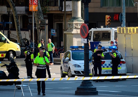 Medical staff members and policemen stand in a cordoned off area after a van ploughed into the crowd, injuring several persons on the Rambla in Barcelona
