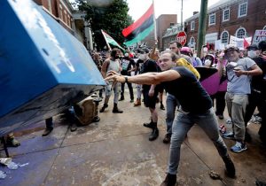 An anti-fascist counter-protester hurls a newspaper box toward white nationalists, neo-Nazis and members of the 'alt-right' during the 'Unite the Right' rally