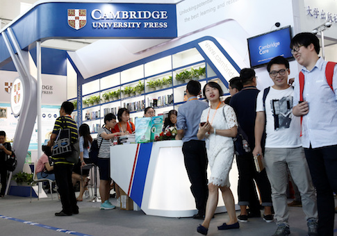 People walk past the Cambridge University Press stall at the Beijing International Book Fair
