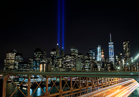 The 'Tribute in Light' rises above the skyline of Lower Manhattan as seen from the Brooklyn Bridge on September 11, 2017