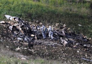 Israeli security forces examine the remains of an F-16 Israeli war plane near the Israeli village of Harduf, Israel