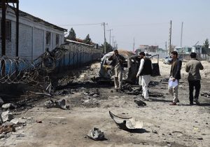Afghan security personnel inspect the site of a Taliban car bomb attack in Kabul