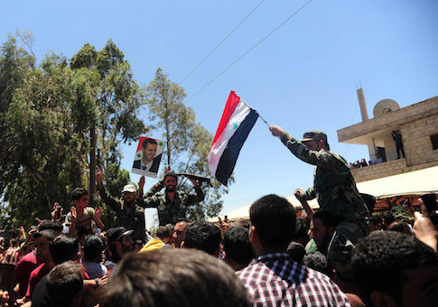 Residents celebrate the army's arrival in the formerly rebel-held town of Ibta, northeast of Deraa city, Syria